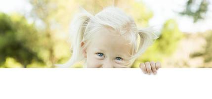 schattig weinig meisje Holding wit bord met kamer voor tekst foto