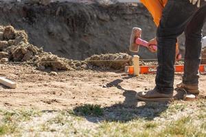 arbeider installeren inzetten en timmerhout gidsen Bij bouw plaats foto