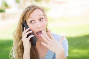 verbijsterd jong vrouw buitenshuis pratend Aan haar slim telefoon. foto
