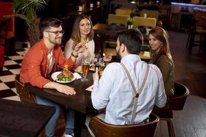 jong mensen hebben avondeten in de restaurant foto