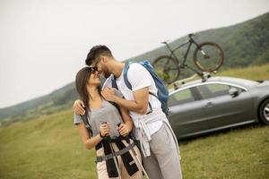 paar van wandelaars met rugzakken beginnend een wandelen door de velden foto