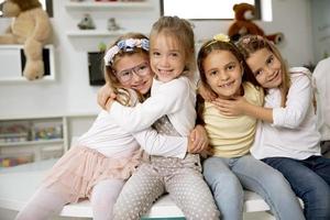 groep van kleuterschool meisje vrienden zittend en hebben pret foto