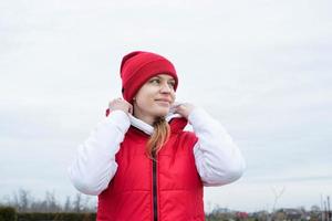 portret van jong vrouw in helder rood en wit sport kleren buitenshuis foto
