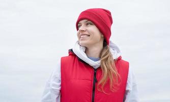 portret van jong vrouw in helder rood en wit sport kleren buitenshuis foto