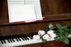 piano, boeket van vijf pale roze rozen Aan toetsenbord, muziek- papier foto