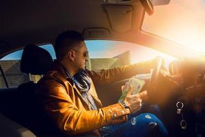 mode model- mannetje het rijden auto met veel van geld in hand- foto