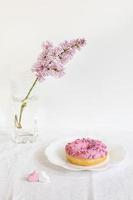 minimaal modern nog steeds leven met lila takje en donut Aan wit achtergrond. foto
