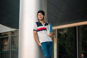 schattig jong leerling jongen in bril met boeken in handen foto