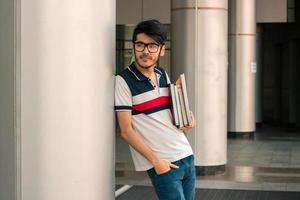 schattig vent in een t-shirt staat Aan de straat en houdt Aan hand- boek foto