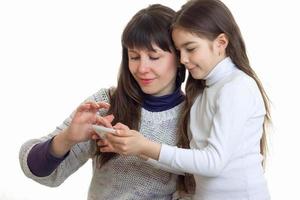 moeder met haar dochter gebruik makend van een mobiel telefoon foto