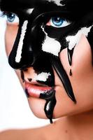 verticaal foto van sexy vrouw met zwart verf Aan gezicht
