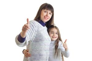 vrolijk volwassen moeder met haar weinig dochter shows duimen omhoog en glimlacht foto