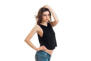 mooi jong brunette in zwart t-shirt houdt hand- haar- en looks richting foto