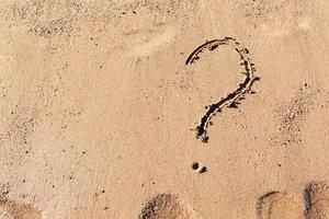 vraag Mark teken Aan zand strand in de buurt de zee. concept van dilemma, antwoord en vraag foto