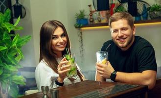 paar drankjes cocktails in de bar en glimlachen Aan camera foto