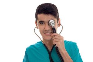jong gelukkig dokter in blauw uniform met stethoscoop Aan zijn nek geïsoleerd Aan wit achtergrond foto