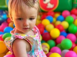 schattig weinig baby meisje hebben pret in de bal zwembad foto