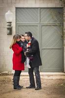 hartelijk gekleed familie liefhebbend zoon in voorkant van rustiek gebouw foto