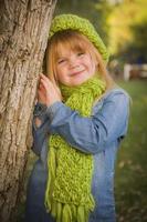 portret van schattig jong meisje vervelend groen sjaal en hoed foto