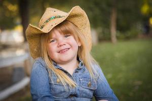 schattig jong meisje vervelend cowboy hoed poseren voor portret buiten foto