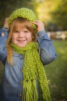 portret van schattig jong meisje vervelend groen sjaal en hoed foto