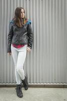 jong tiener meisje staand tegen metaal muur foto