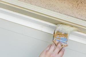 professioneel schilder snijdend in met borstel naar verf garage deur kader foto
