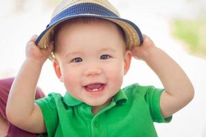 portret van een gelukkig gemengd ras Chinese en Kaukasisch baby jongen vervelend zijn hoed foto