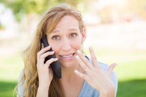 verbijsterd jong vrouw buitenshuis pratend Aan haar slim telefoon. foto