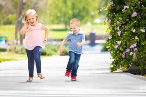 jong zus en broer hebben pret rennen Bij de park foto