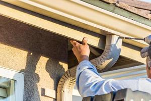 arbeider Vastmaken aluminium regen goot en naar beneden tuit naar bindweefsel van huis foto