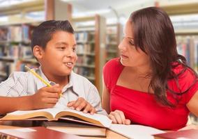 spaans jong jongen en familie volwassen aan het studeren Bij bibliotheek foto