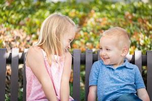 jong zus en broer hebben pret Aan de bank Bij de park foto