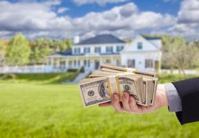 overhandigen over- contant geld voor huis in voorkant van huis foto