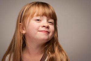 pret portret van een aanbiddelijk rood haren meisje Aan grijs foto