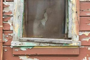 verweerd hout paneel muur en venster met pellen verf getextureerde achtergrond foto