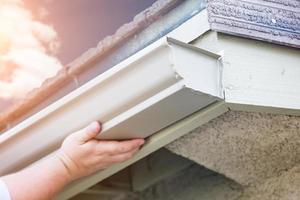 arbeider Vastmaken aluminium regen goot naar bindweefsel van huis foto