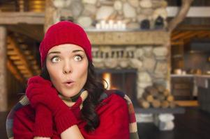 gemengd ras meisje genieten van warm haard in rustiek cabine foto