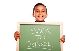 schattig spaans jongen Holding schoolbord met terug naar school- foto