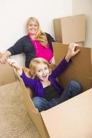 jong familie in leeg kamer spelen met in beweging dozen foto