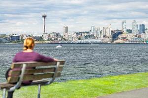 vrouw zittend Aan bank op zoek Bij de Seattle, Washington horizon foto