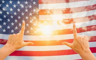 handen framing zon schijnend door Amerikaans vlag foto