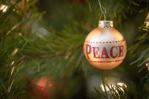 vrede geschreven Aan Kerstmis ornament hangende Aan boom foto