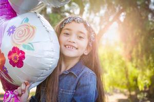 schattig jong gemengd ras meisje Holding mylar ballon buitenshuis foto