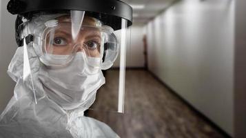 banier van vrouw dokter of verpleegster in medisch gezicht masker schild en beschermend uitrusting in ziekenhuis gang foto