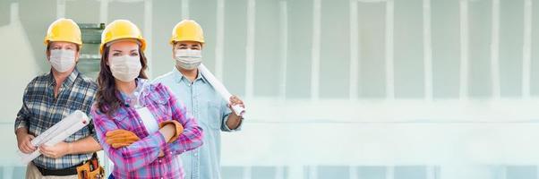 vrouw en mannetje aannemers in moeilijk hoeden vervelend medisch gezicht maskers Bij bouw plaats gedurende coronavirus pandemisch banier foto