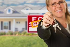 echt landgoed middel overhandigen over- nieuw huis sleutels met verkocht teken achter foto