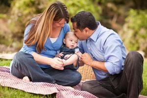 gelukkig gemengd ras familie spelen in de park foto