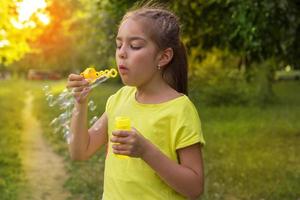 portret van schattig weinig meisje dat staat Aan de straat en zet bubbels foto