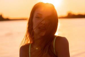seksueel jong dame in de zee Bij warm zonsondergang foto